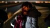 El migrante cubano Mario Pérez sostiene a su esposa mientras esperan ser procesados ​​para solicitar asilo, luego de cruzar la frontera hacia EEUU, el 6 de enero de 2023, cerca de Yuma, Arizona. (AP/Gregory Bull)