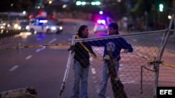 Dos personas preparan una barricada en una calle de Caracas (Venezuela) que está sumida en una ola de protestas desde el 12 de febrero cuando una manifestación pacífica en la capital degeneró en actos de violencia contra edificios públicos.