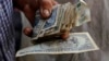 Un hombre sostiene pesos cubanos. REUTERS/Desmond Boylan