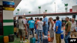 Cubanos hacen fila con sus bidones para comprar gasolina en La Habana tras el anuncio de la crisis de combustible. Foto: YAMIL LAGE / AFP.