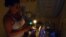 Una mujer prepara la comida en la cocina, iluminada con velas, durante un apagón en el barrio de Alamar