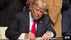 El presidente estadounidense, Donald J. Trump, firma el memorando presidencial sobre la política con Cuba tras finalizar su discurso en el teatro Manuel Artime de la Pequeña Habana, en Miami.