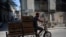 Un hombre transporta frutas en su triciclo por calle de La Habana. (YAMIL LAGE / AFP)