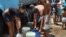 Cubanos se abastecen de agua en pipas.