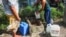 Un cubano llena contenedores de agua en Consolación del Sur en Pinar del Río. FOTO AFP/Yamil Lage.
