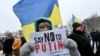 "Diga NO a Putin" pide el cartel que porta una manifestante pacífica en Ucrania