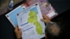 Un miembro de la Asamblea Nacional de Venezuela sostiene un mapa de la diputada región del Esequibo, en Guyana. (REUTERS/Leonardo Fernandez Viloria)