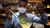 Con una máscara para protegerse del nuevo coronavirus, el cantinero Dagoberto Jesús Morejón prepara un "Martini de Oro", un cóctel con una planta endémica de Cuba llamada "Orozus de la Tierra".