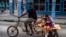 Un hombre transporta niños en su triciclo, en La Habana, en medio de la pandemia de coronavirus en enero del 2021. (Foto AP / Ramón Espinosa).