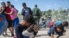Una familia de inmigrantes después de romper una barricada de alambre de púas hacia los Estados Unidos, después de horas de espera en el Río Grande, en Eagle Pass, Texas, el 25 de septiembre de 2023. ANDREW CABALLERO-REYNOLDS / AFP.