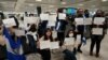 Activistas sostienen carteles con los nombres de algunos de los más de 200 presos políticos liberados de Nicaragua, mientras esperaban su llegada al Aeropuerto Internacional Dulles en Virginia, en las afueras de Washington, EEUU, el 9 de febrero de 2023. (Reuters/Kevin Lamarque).